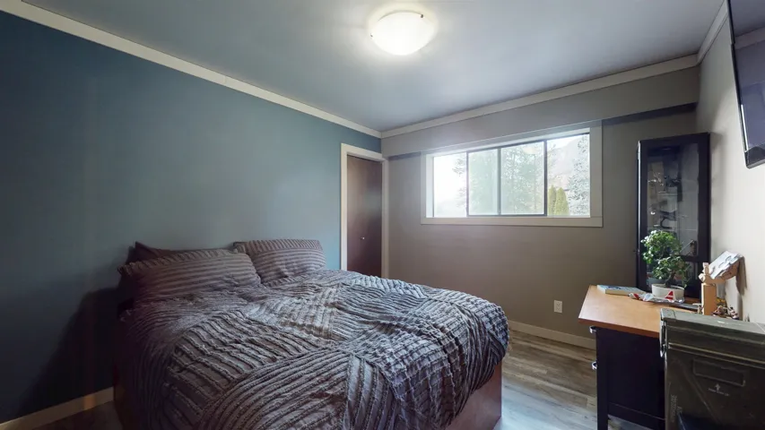 Bedroom with baseboards, wood finished floors, and crown molding