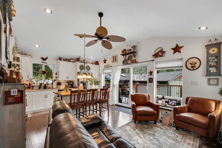Open-concept living area with a vaulted ceiling, recessed lighting, and wood-finish flooring