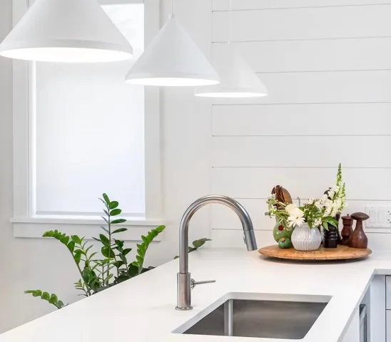 Modern kitchen featuring white cabinetry, stainless steel appliances, and a central island with an integrated sink