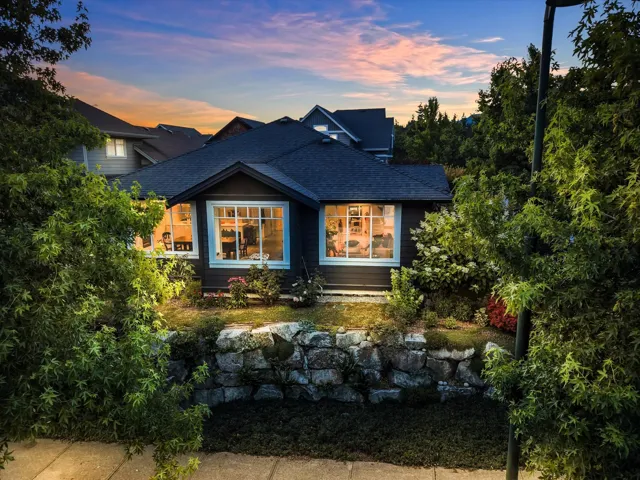 Exterior featuring dark siding, white window trim, and a gabled roofline