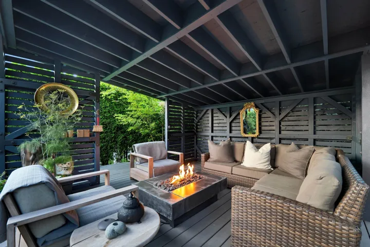 Covered outdoor living area featuring a wood-finish deck
