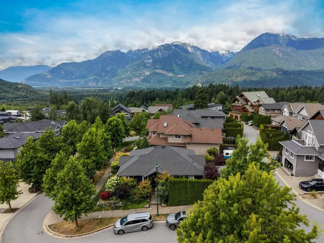 Residential neighborhood featuring mature trees and mountain scenery