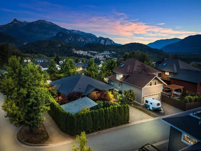 Residential neighborhood featuring multiple homes with pitched roofs and surrounding mature trees