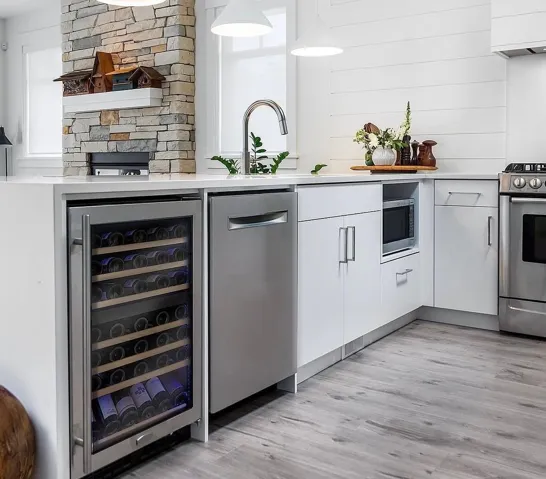Contemporary kitchen featuring white shiplap walls and three conical pendant lights