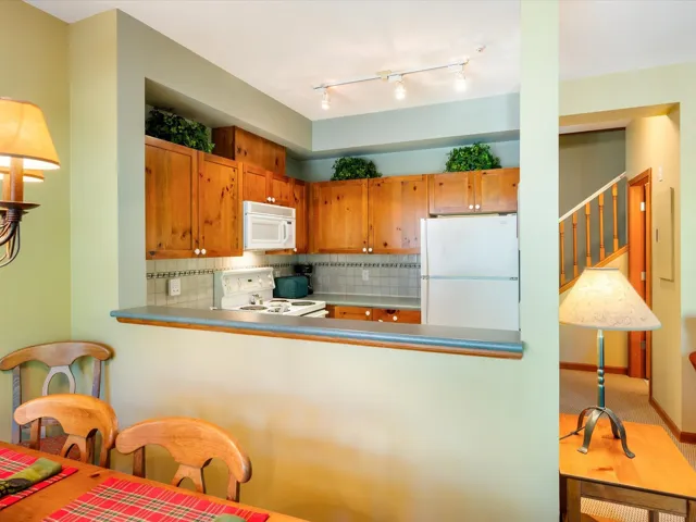 Kitchen with white appliances, decorative backsplash, and a peninsula