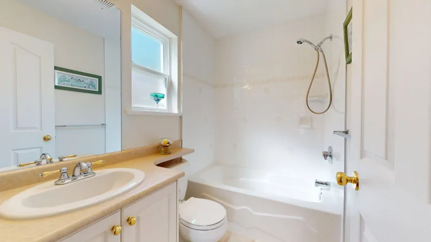 Bathroom featuring toilet, vanity, and shower / tub combination