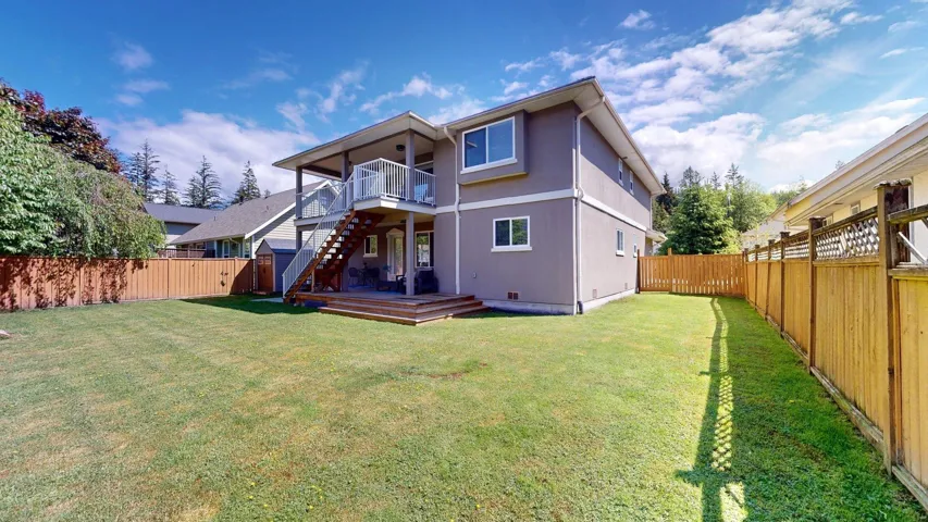 Rear view of property with stairs and a wooden deck