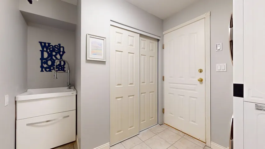 Foyer entrance featuring light tile patterned floors and baseboards