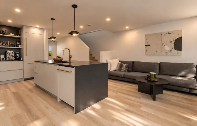 Kitchen island featuring dark stone surfacing, integrated cabinetry, and metallic hardware