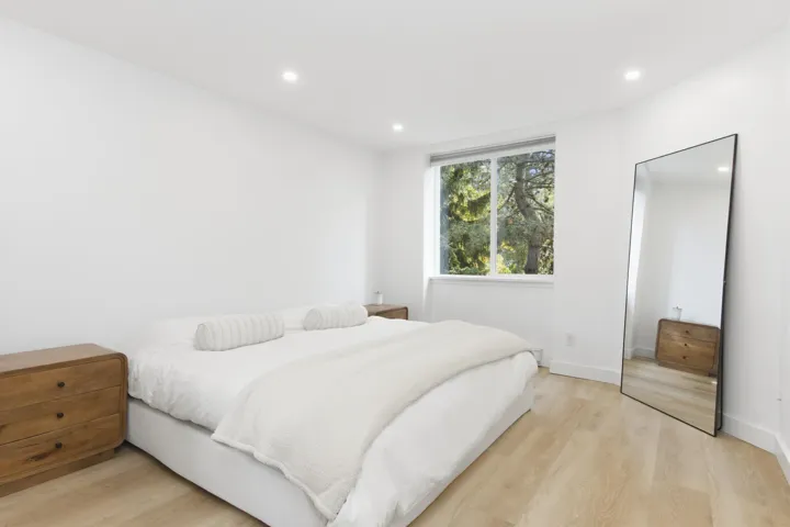 Wood-finish flooring, recessed lighting, and a single-pane window with a nature outlook