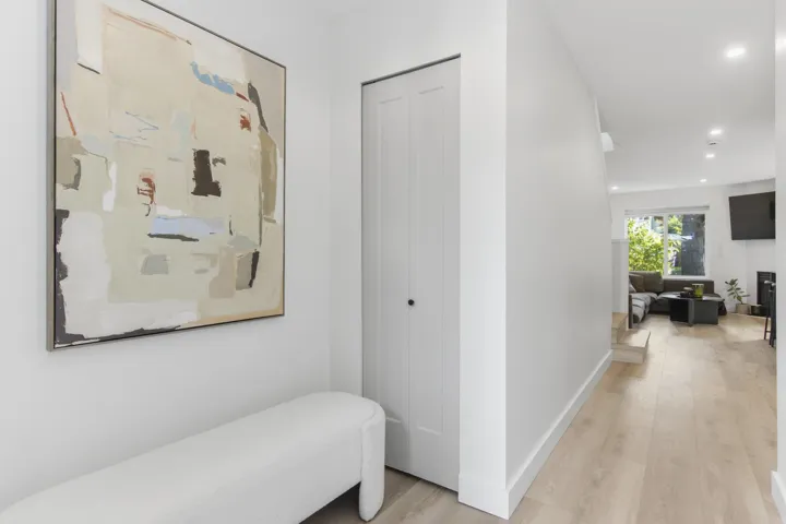 Light-toned wood-finish flooring, recessed lighting, and a white bi-fold closet door