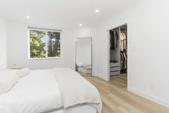 Wood-finish flooring, recessed lighting, and a walk-in closet with built-in shelving