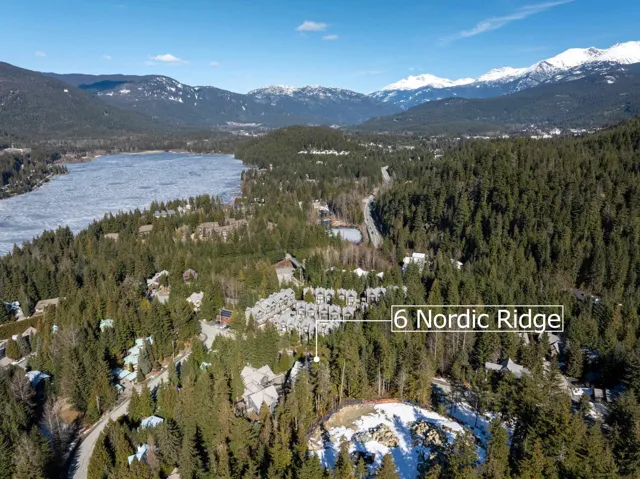 Birds eye view of property featuring a forest view and a water and mountain view