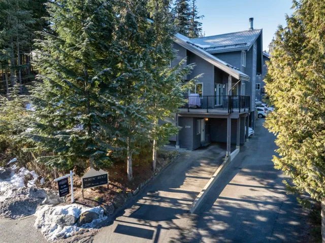 View of front of property with a carport, driveway, and metal roof
