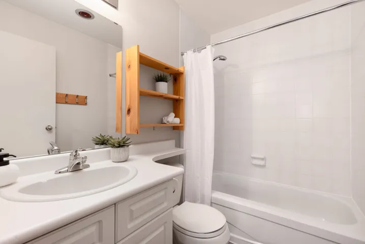 Bathroom featuring toilet, shower / bath combo, and vanity
