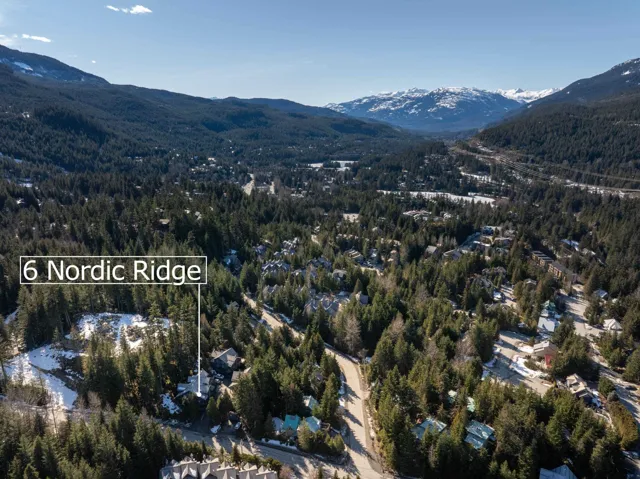 Birds eye view of property with a mountain view and a view of trees