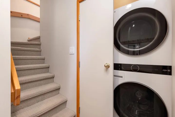 Laundry area with laundry area and stacked washer and dryer