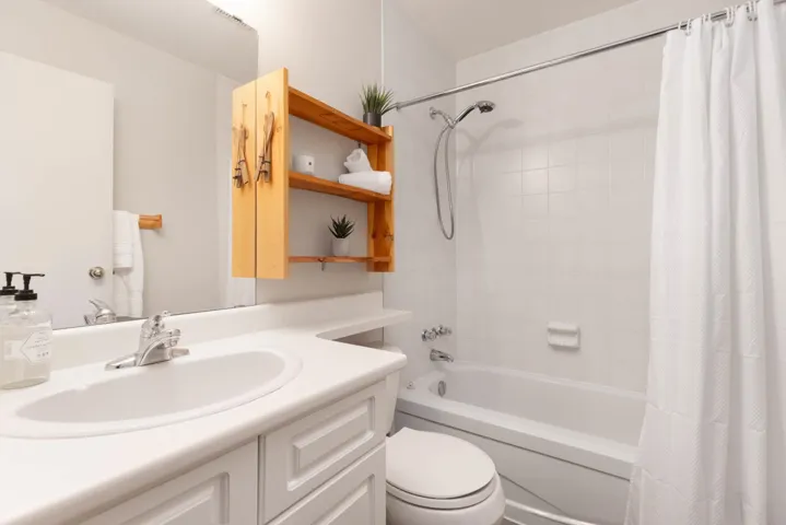 Full bathroom with vanity, toilet, and shower / tub combo with curtain