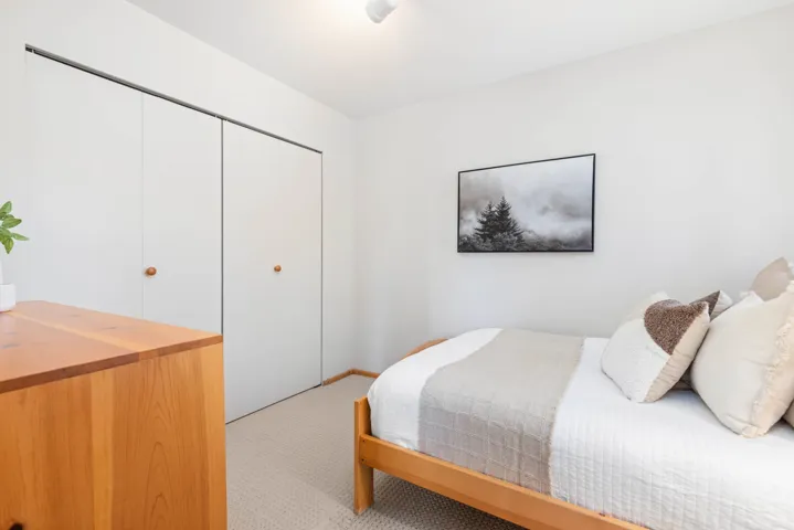Bedroom with light colored carpet and a closet