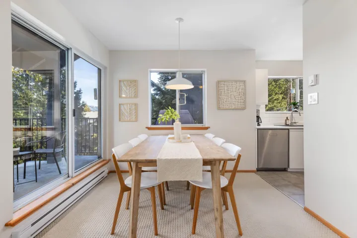 Dining room with a baseboard radiator, baseboards, and light carpet