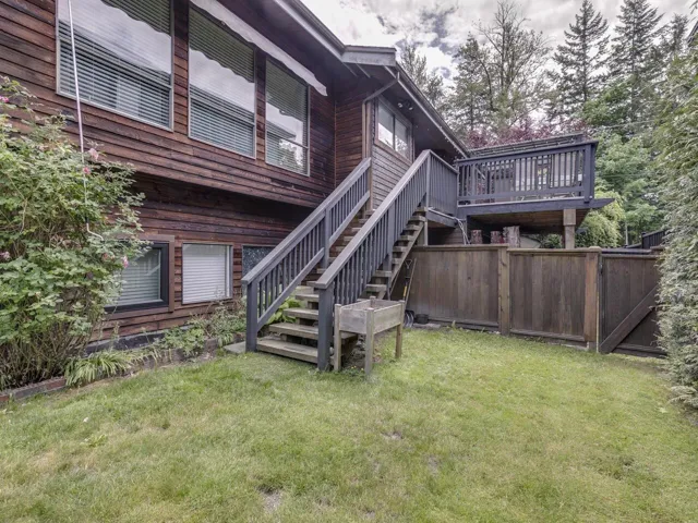 Side view of property featuring stairs and a deck