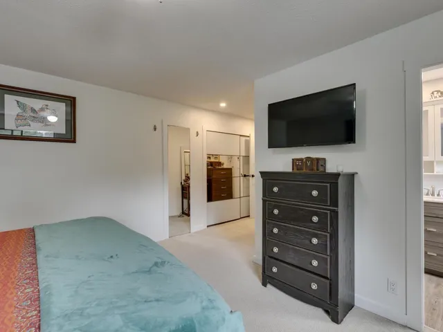 Bedroom featuring light colored carpet, recessed lighting, with renovated 3 piece ensuite bathroom.