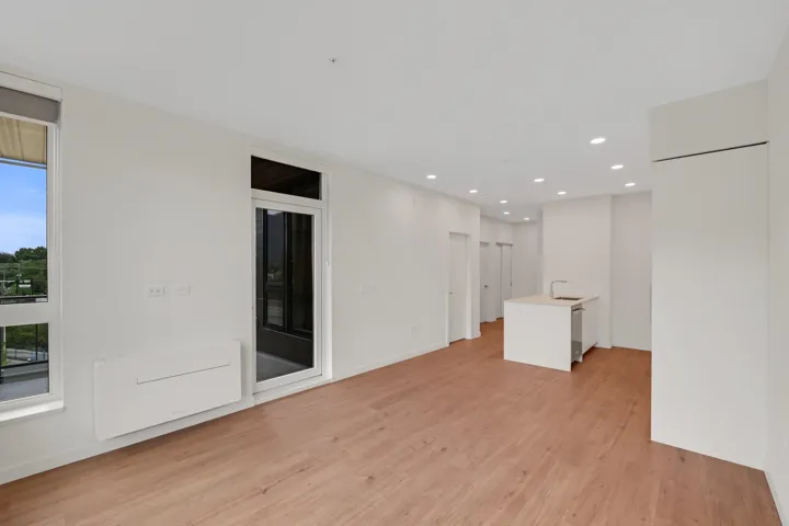 Open-concept living space featuring wood-finish flooring, recessed lighting, and white walls