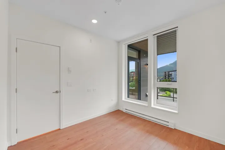 Well-lit interior space featuring wood-finish flooring, white walls, and a recessed ceiling light