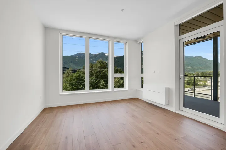 Bright interior space featuring wood-finish flooring, white baseboards, and a neutral wall palette