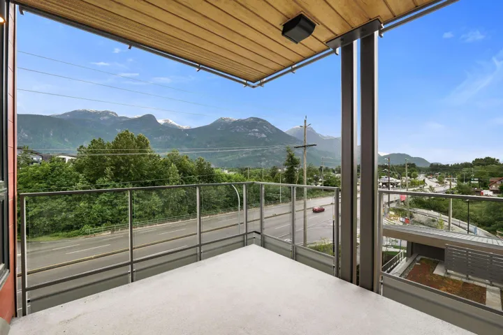 Outdoor balcony featuring a concrete floor, glass railing, and a wood-finish ceiling