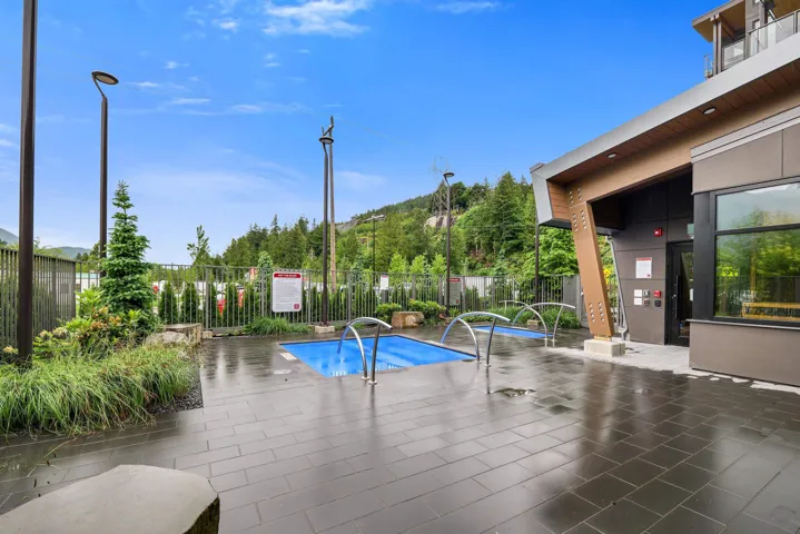 Outdoor amenity area featuring two ground-level water features surrounded by dark tile pavers