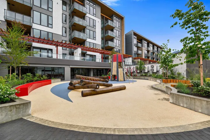 Contemporary residential building with private balconies and a ground-level patio area
