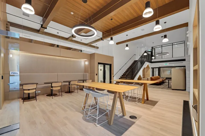 Open concept common area featuring wood-finish flooring, exposed beam ceiling, and mixed pendant lighting