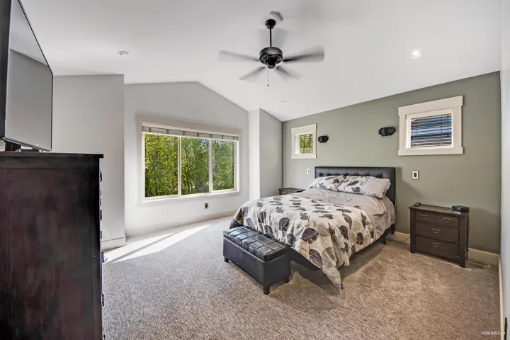 Carpeted bedroom with baseboards, a ceiling fan, and lofted ceiling