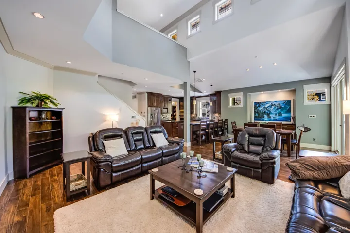 Living area with dark wood-style flooring, recessed lighting, and baseboards
