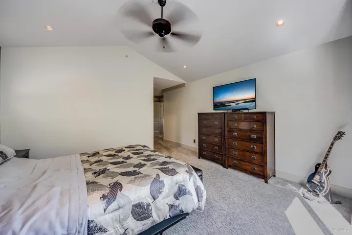 Bedroom featuring ceiling fan, recessed lighting, vaulted ceiling, and light carpet