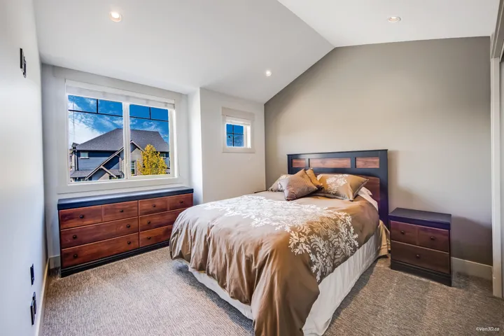 Carpeted bedroom featuring recessed lighting, multiple windows, and lofted ceiling