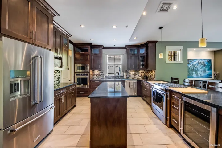 Kitchen featuring tasteful backsplash, beverage cooler, visible vents, dark brown cabinetry, and high quality appliances