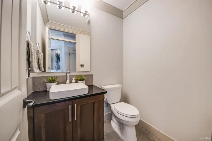 Bathroom with toilet, tile patterned floors, vanity, and baseboards