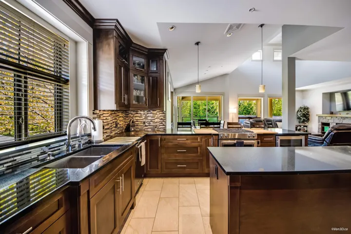 Kitchen featuring a sink, wine cooler, tasteful backsplash, vaulted ceiling, and open floor plan
