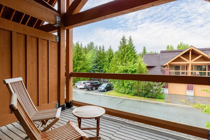 Spacious balcony featuring wood-finish decking and exposed timber beams