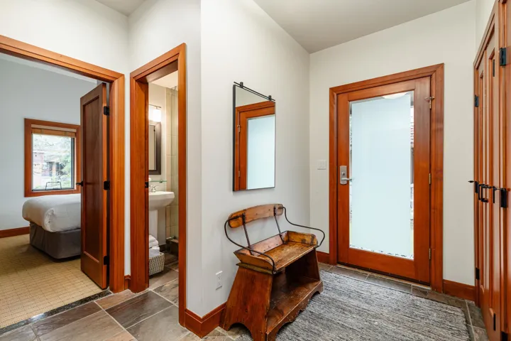 Foyer area featuring natural wood trim and doors, slate tile flooring, and a frosted glass entry door