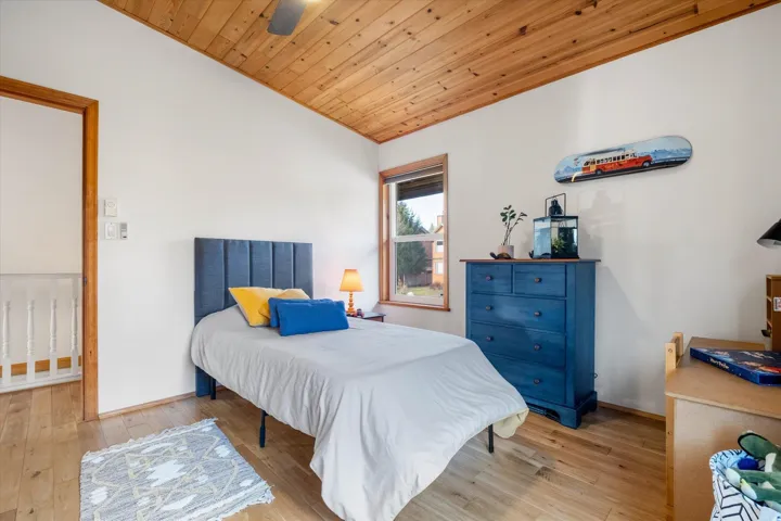 Bedroom featuring a vaulted wooden ceiling, light wood-type flooring, and ceiling fan