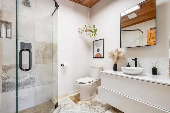 Bathroom featuring vanity, wood ceiling, and a stall shower