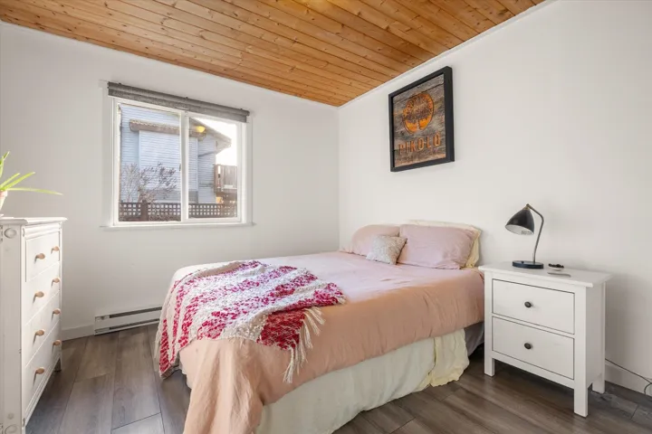 Bedroom with wood ceiling, dark wood-type flooring, and a baseboard radiator