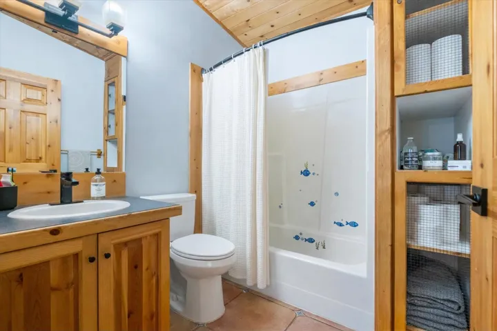 Full bathroom featuring shower / bathtub combination with curtain, light tile patterned floors, and vanity