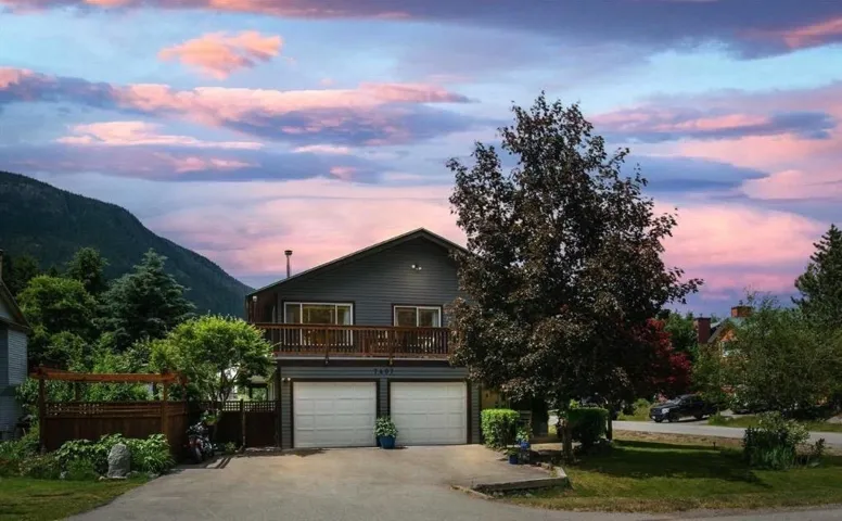 View of front of property with driveway, a garage, and a mountain view