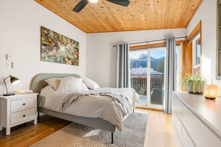Bedroom with wood ceiling, access to exterior, ceiling fan, light wood finished floors, and a mountain view