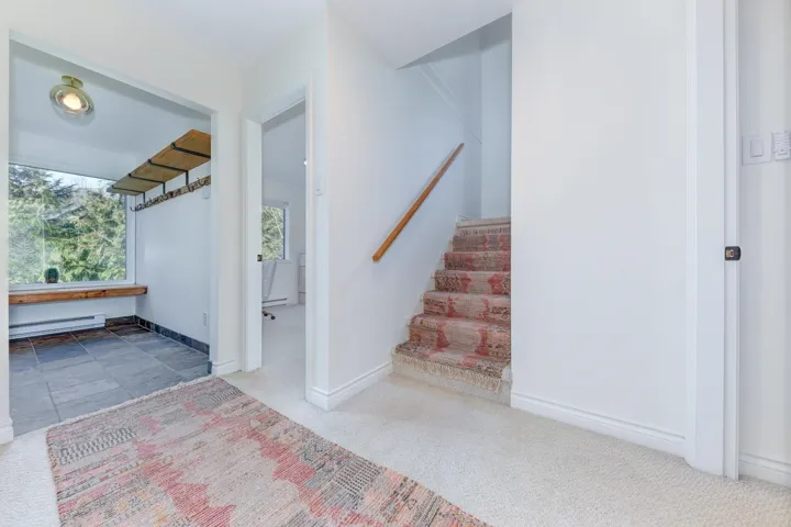 Stairs with carpet floors and a baseboard heating unit