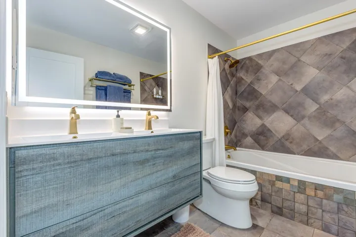 Bathroom featuring double vanity and tiled shower / bath combo